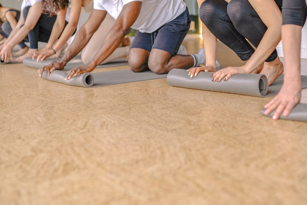 Foto von Pexels von Leuten die eine Yogamatte ausrollen